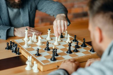 Erkek satranç oyuncuları, düşünme süreci oynuyor. İki satranç oyuncusu, entelektüel turnuvaya kapalı olarak başlar. Ahşap masa üzerinde chessboard, strateji oyunu