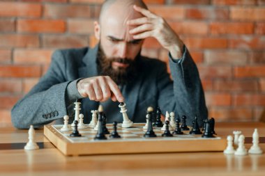 Erkek satranç oyuncusu kaybettiğini anladı, şah mat. Gemide chessplayer, ön görüş, entelektüel turnuva kapalı. Ahşap masa üzerinde chessboard, strateji oyunu