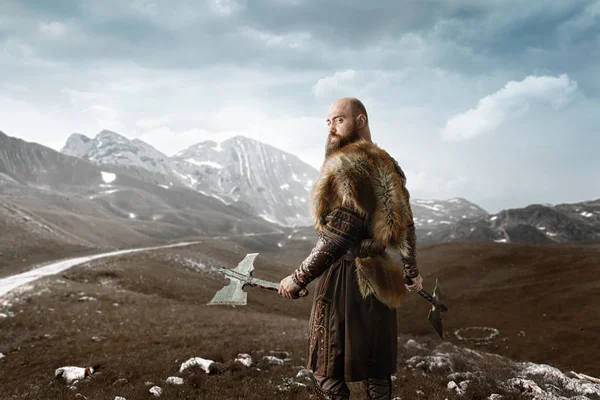 维京人手拿斧头 身着传统的北欧服装 站在岩石山上 斯堪的纳维亚古代战士 — 图库照片