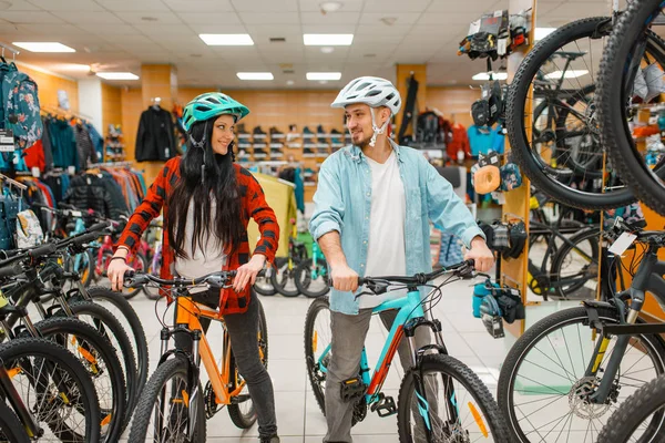 自転車を選ぶサイクリングヘルメットのカップル スポーツショップでのショッピング 夏の季節の極端なライフスタイル アクティブなレジャーストア 顧客の購入サイクル — ストック写真