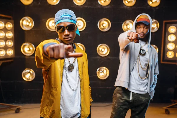 Dois Rappers Africanos Bonés Artistas Posando Palco Com Holofotes Fundo — Fotografia de Stock