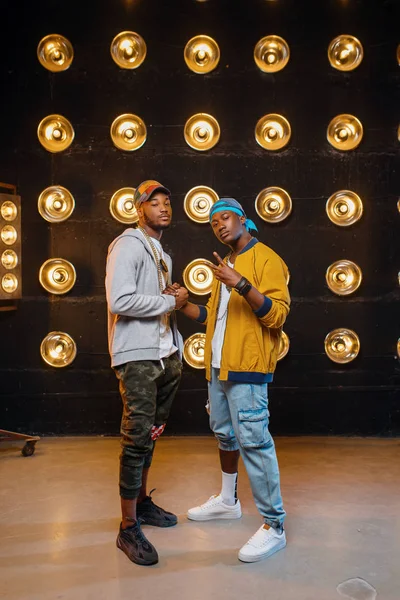 Dois Rappers Africanos Bonés Artistas Posa Palco Com Holofotes Fundo — Fotografia de Stock