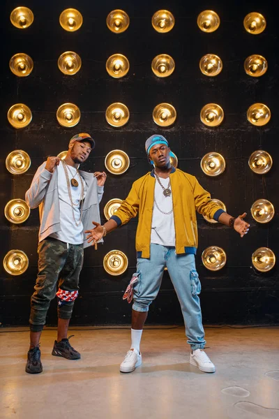 Dois Rappers Pretos Bonés Posam Palco Com Holofotes Fundo Artistas — Fotografia de Stock