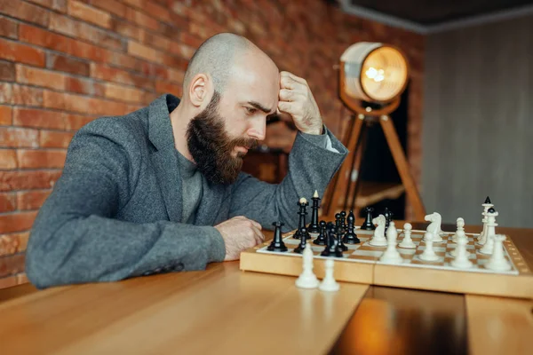 黒い数字を再生する男性チェスプレーヤー 思考プロセス ボードでチェスプレーヤー 屋内の知的トーナメント 木製テーブル 戦略ゲーム上のチェスボード — ストック写真