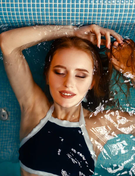 Jonge Vrouw Ligt Het Zwembad Binnen Bovenaanzicht Ontspannende Watermassage Zwemmen — Stockfoto