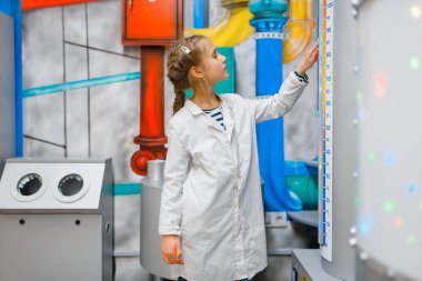 Üniformalı küçük çocuk laboratuarda doktorluk oynuyor, oyun odası. Çocuk hayali hastane laboratuvarında tıp işçisi oynuyor, meslek öğrenme, çocukça rüya