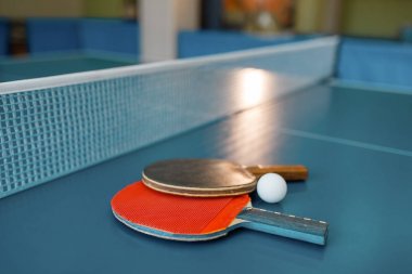 Net ile masada iki ping pong kürekler, kimse, yakın çekim görünümü. Masa tenisi kulübü, tenis konsepti