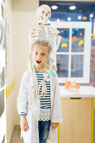 Маленькая Девочка Форме Рядом Человеческим Скелетом Играет Доктора Игровую Комнату — стоковое фото