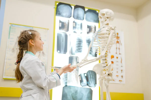 Liten Flicka Uniform Leker Läkare Med Mänskligt Skelett Lekrum Unge — Stockfoto