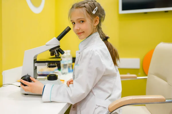 Mała Dziewczynka Mundurze Siedzi Mikroskopie Gra Doktor Pokój Zabaw Dziecko — Zdjęcie stockowe