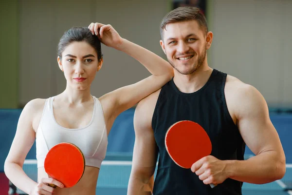 남자와 여자는 실내에서 라켓을 스포츠웨어를 커플은 체육관에서 탁구를 합니다 클럽의 — 스톡 사진