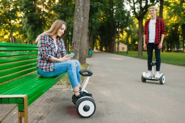 Yaz parkında gyro kurulu ile genç çift leisures. Elektrikli gyroboard ile açık hava rekreasyon. Denge teknolojisi ile taşıma