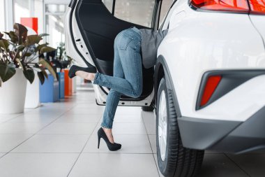 Çekici kadının kıçı showroom'da yeni arabadan çıkıyor. Bayilik, otomobil satışı, oto satın alma araç seçen kadın müşteriler