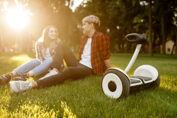 Jong Stel Zittend Het Gras Buurt Van Gyro Board Zomerpark — Stockfoto