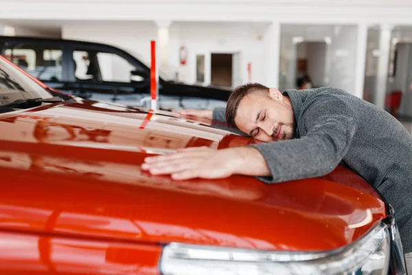 Człowiek Leżący Masce Nowego Samochodu Showroom Mężczyzna Nabywcy Zakupu Pojazdu — Zdjęcie stockowe