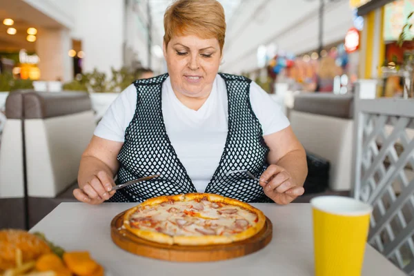 ファーストフードレストランでピザを食べる太った女性 ジャンクディナー 肥満の問題でテーブルで太りすぎの女性 — ストック写真