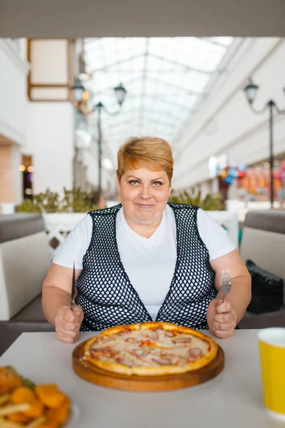 ファーストフードレストランでピザを食べる太った女性 ジャンクディナー 肥満の問題でテーブルで太りすぎの女性 — ストック写真