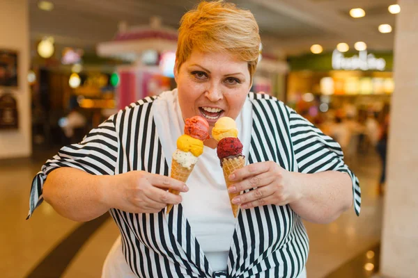 ファーストフードモールのレストランで2つのアイスクリームを食べる太った女性 アイスクリーム 肥満の問題を持つ太りすぎの女性 — ストック写真