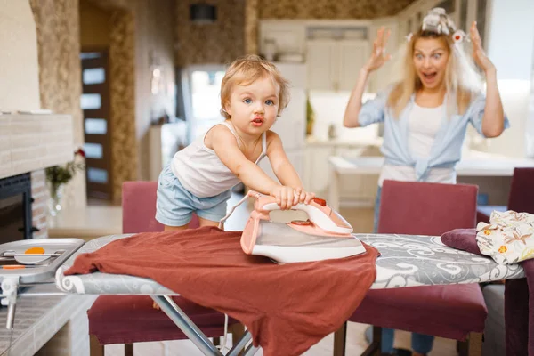 小さな赤ちゃんは台所に服をアイロンをかけ 恐怖の主婦 家で家事をする子供幼い子供が家を掃除する — ストック写真