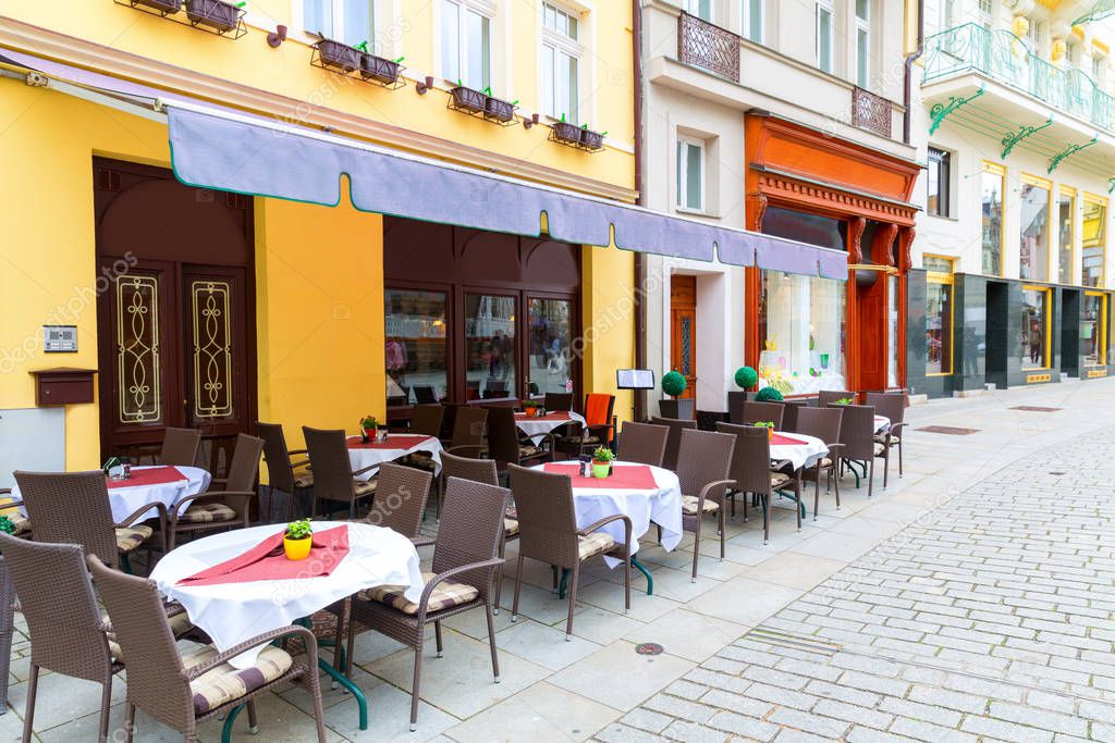 Cosy outdoor cafe on the cobblestone street, Karlovy Vary, Czech Republic, Europe. Old european town, famous place for travel and tourism