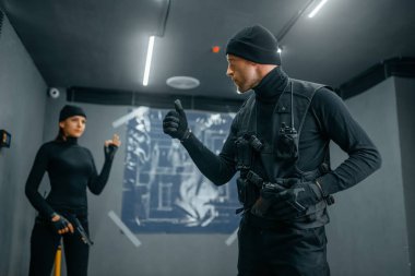 Soyguncular banka kasası soygununa başlıyor. Suç mesleği, hırsızlık konsepti, siyah üniformalı erkek ve kadın haydutlar.