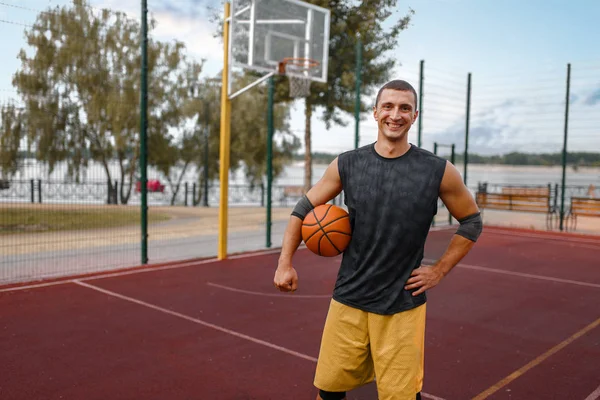 户外运动场地上的肌肉篮球运动员 身穿运动服的男子运动员在街头篮球训练中持球 — 图库照片