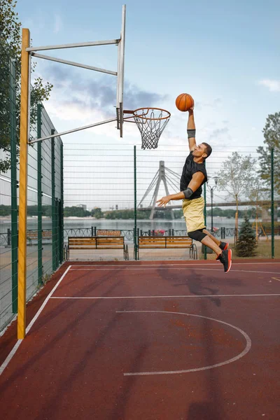 バスケットボール選手はジャンプでシュートを行います スポーツウェアの男性選手 ストリートボールトレーニングのスコア — ストック写真
