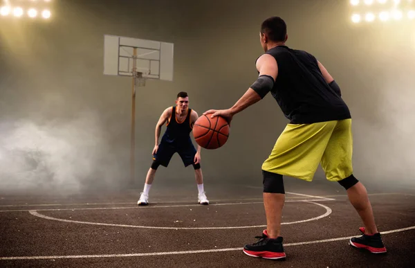 2人のバスケットボール選手は戦術を練習します 暗い背景 スポーツウェアの男性選手は ストリートボールのトレーニングでゲームをプレイ — ストック写真