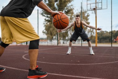 İki basketbolcu dışarıda taktik çalışıyor. Spor giyim sektöründe erkek sporcular sokak topu antrenmanında oynuyor.