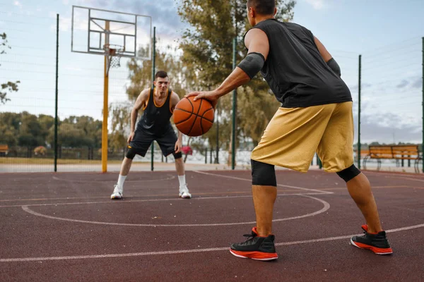 两名篮球运动员在室外场地上练习战术 男子运动员穿着运动服在街头篮球训练中比赛 — 图库照片