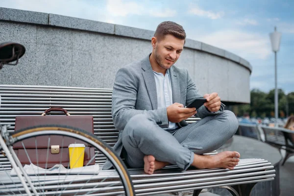 市中心办公大楼的长椅上坐着骑自行车的商人 在城市街道上乘坐生态交通工具的商人 城市风格 — 图库照片