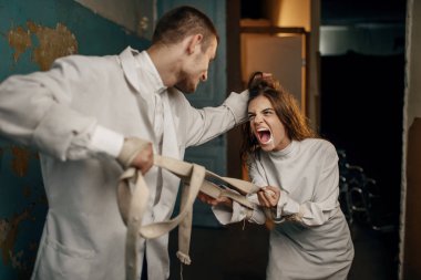 Erkek psikiyatrist ve deli kadın hasta bir öfke nöbetinde, akıl hastanesinde. Deli gömleği giymiş bir kadın akıl hastası olduğu için klinikte tedavi görüyor.