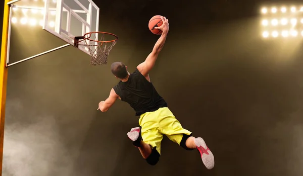 バスケットボール選手はジャンプ 暗い背景で撮影を行います スポーツウェアの男性選手 ストリートボールトレーニングのスコア — ストック写真