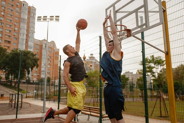 两个篮球运动员在室外场地上打球 男子运动员穿着运动服在街头篮球训练中比赛 — 图库照片