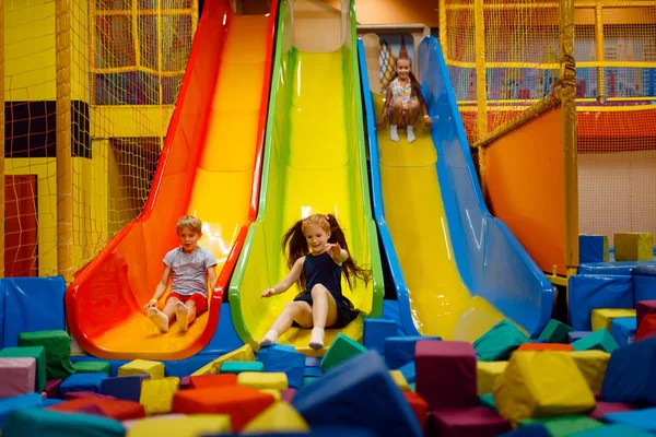 インフレータブルスライド エンターテイメントセンターの遊び場で楽しんでいる小さな子供たち 屋内プレイエリア プレイルーム — ストック写真