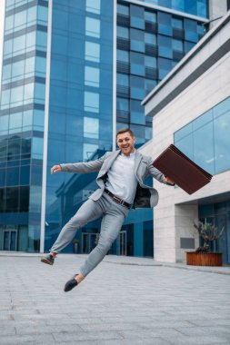 Şehir merkezindeki ofis binasında bisikletli mutlu bir işadamı.