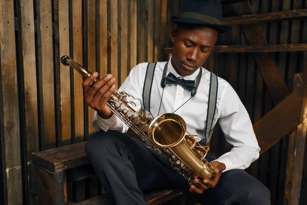 Afrikaanse Jazzmuzikant Met Saxofoon Houten Fenchachtergrond Zwarte Jazzman Hoed Poseert — Stockfoto