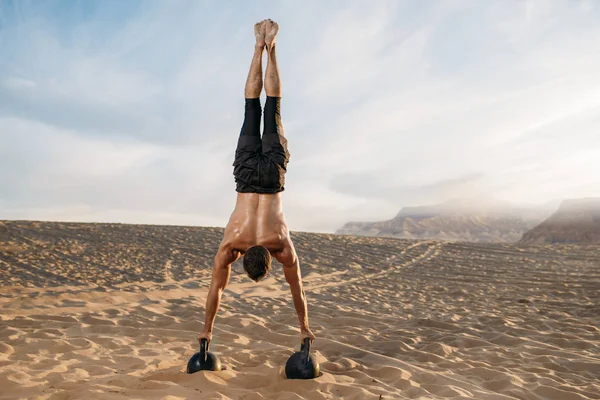 Manlig Idrottsman Gör Övningar Med Två Kettlebells Står Händerna Öknen — Stockfoto