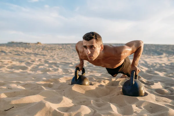 Atleta Masculino Fazendo Exercícios Push Com Dois Kettlebells Deserto Dia — Fotografia de Stock