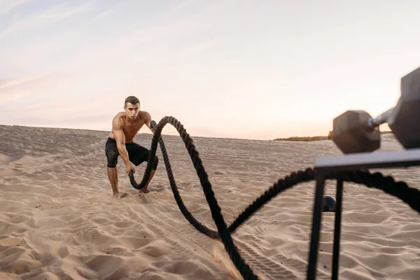 Atleta Masculino Fazendo Exercício Com Cordas Batalha Deserto Dia Ensolarado — Fotografia de Stock