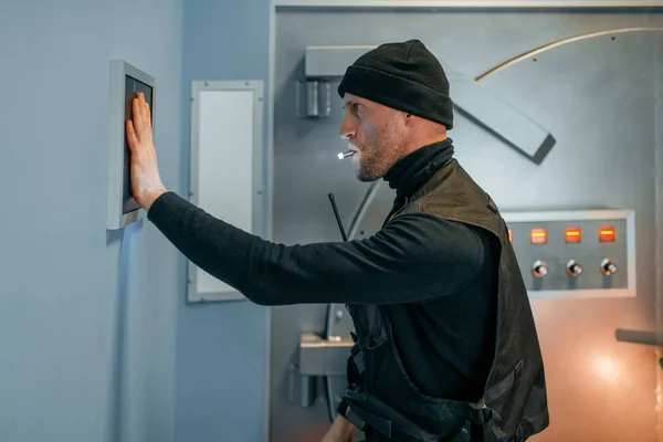 銀行強盗黒い制服の男強盗金庫室のドアを開けようとしてる犯罪者の職業窃盗の概念 — ストック写真
