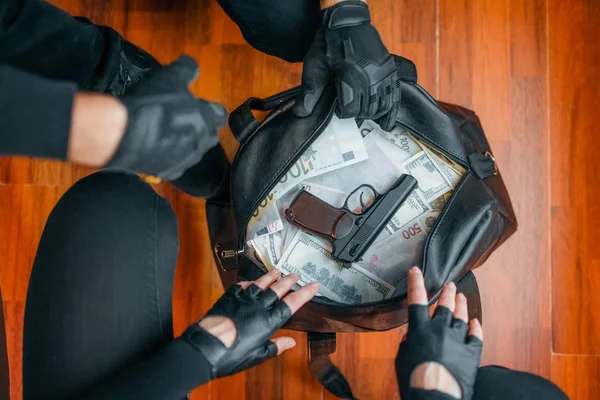 銀行強盗黒の制服を着た２人の強盗が金の入ったバッグを持ってる犯罪者の職業窃盗の概念 — ストック写真