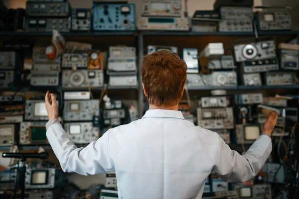 Παράξενος Επιστήμονας Ψάχνει Στο Ράφι Ηλεκτρονικές Συσκευές Στο Εργαστήριο Πίσω — Φωτογραφία Αρχείου