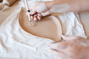 Kadın çömlekçi bir kalıp çizer, çömlek atölyesi. Çalışan kadın kalıpları. El yapımı seramik sanat, kilden sofra takımı