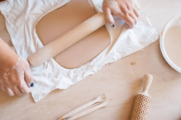 女陶工用滚动销和陶瓷作坊把前臂伸出来 女性成型的工作材料 手工陶瓷艺术 陶制餐具 — 图库照片