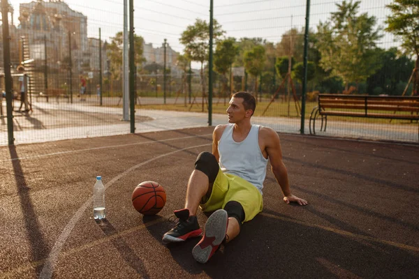 Basketball Player Sitting Ground Drinks Water Outdoor Court Male Athlete — Stock Photo, Image