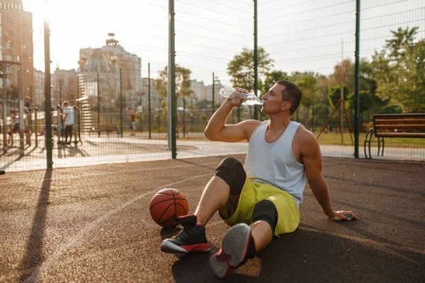 Basketball Player Sitting Ground Drinks Water Outdoor Court Male Athlete — Stock Photo, Image