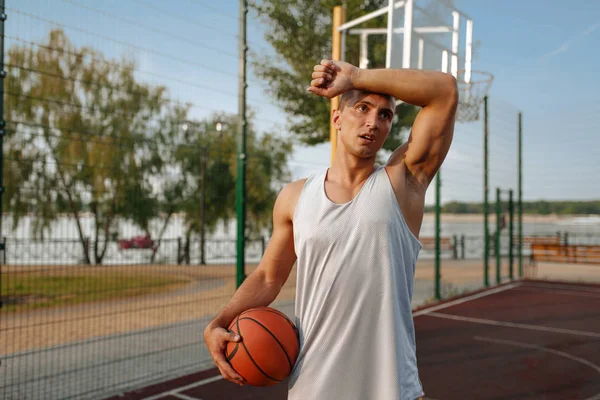 疲惫的男篮手 球落在室外场地 前视镜 男子运动员穿着运动服参加街球训练 夏季体育场 — 图库照片
