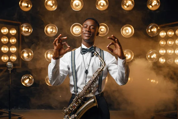 Africano Sonriente Intérprete Jazz Con Saxofón Muestra Signo Escenario Con —  Fotos de Stock