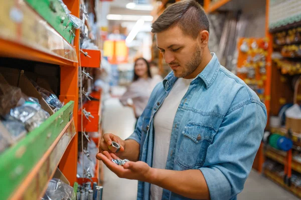 ハードウェア店でナッツを選ぶ男性消費者 お客様は スーパーマーケットを構築する上で買い物 ダイイショップで商品を見て — ストック写真